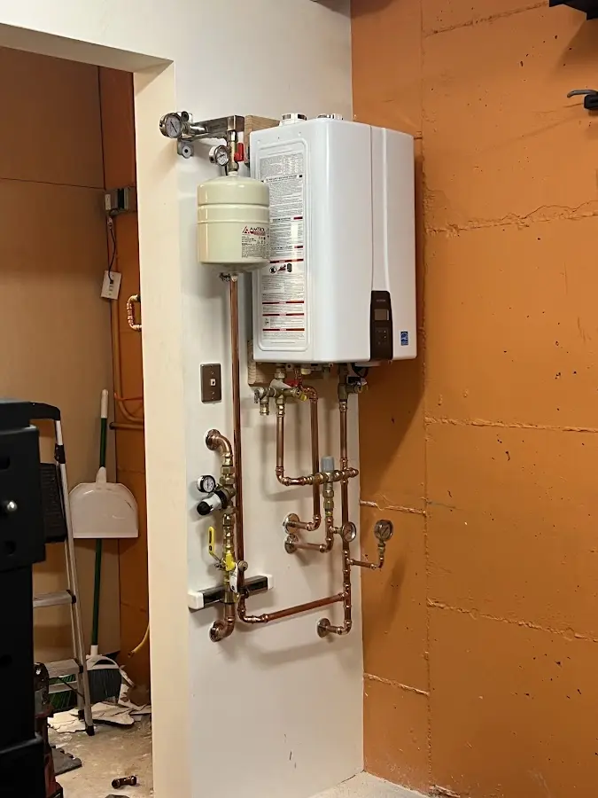 Plumbing technician inspecting water heater connections in New Haven